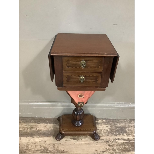 417 - A mahogany Pembroke work table with two drawers and well, pedestal base with platform and foliate fe... 