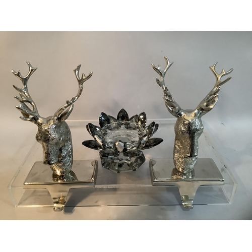 73 - A pair of white metal table hooks formed as stags together with a moulded glass candle holder in the... 