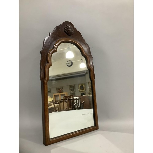 390 - An early 20th century walnut shield shaped mirror having a carved shell pediment, 57cm x 33cm