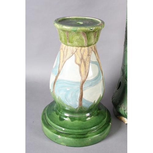 55B - An early 20th century Burmantoft's umbrella / stick stand, tube lined in green glaze and moulded wit... 