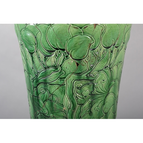55B - An early 20th century Burmantoft's umbrella / stick stand, tube lined in green glaze and moulded wit... 
