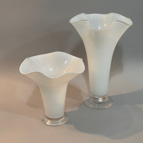 17 - A pair of Orrefors white glass vases of graduated size with flared wavy rims on clear glass foot, et... 