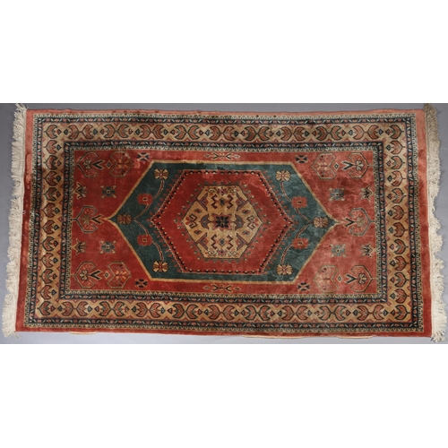 106 - A Caucasian silk carpet, the coral field having a turquoise and coral medallion with geometric motif... 