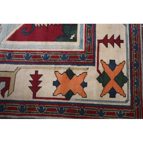 107 - A Kazak carpet, the pale blue ground having a maroon panel and spandrels filled with geometric motif... 