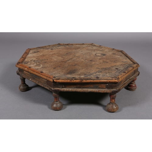 51 - A low Eastern fruitwood octagonal table with wrought iron brackets on eight bun feet, 82cm x 17cm