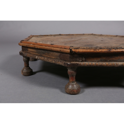 51 - A low Eastern fruitwood octagonal table with wrought iron brackets on eight bun feet, 82cm x 17cm