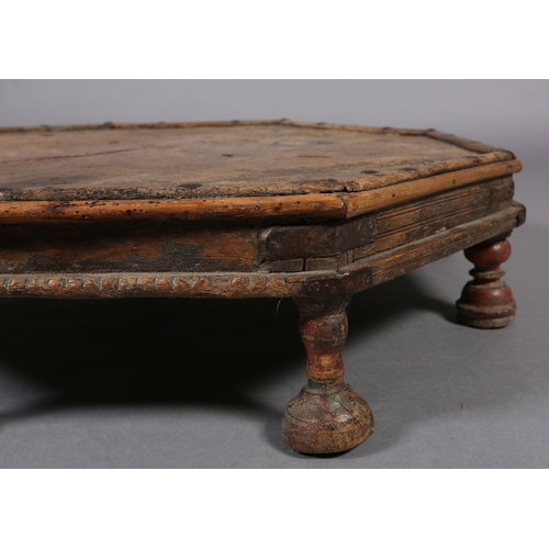 51 - A low Eastern fruitwood octagonal table with wrought iron brackets on eight bun feet, 82cm x 17cm