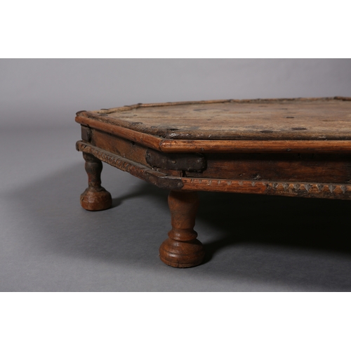 51 - A low Eastern fruitwood octagonal table with wrought iron brackets on eight bun feet, 82cm x 17cm