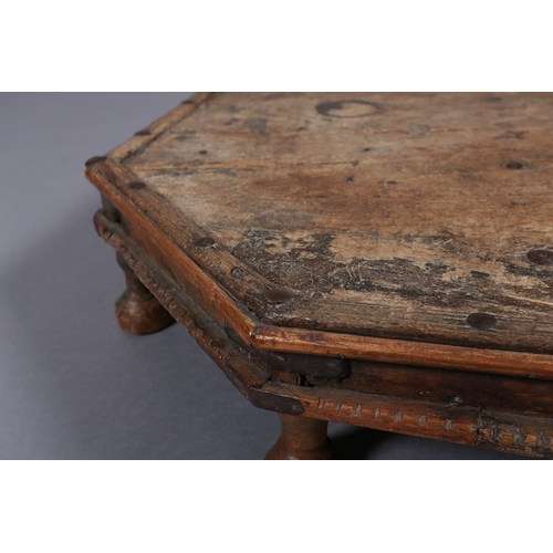 51 - A low Eastern fruitwood octagonal table with wrought iron brackets on eight bun feet, 82cm x 17cm