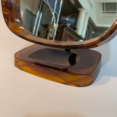 99 - A Danish plastic faux tortoiseshell dressing table mirror on a dished pedestal base 28cm wide x 36.5... 