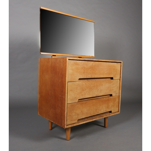 84 - An early 1970s beech and mirrored dressing chest of three drawers on rounded and tapered legs, 76cm ... 