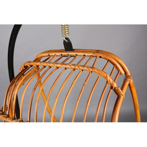 116 - A rattan basket swing chair, pendant from a black metal tubular frame