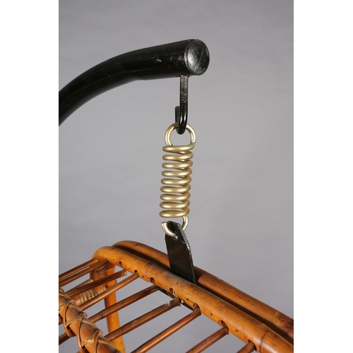 116 - A rattan basket swing chair, pendant from a black metal tubular frame