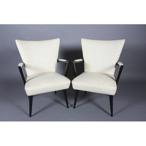 31 - A pair of 1950s black framed cocktail lounge chairs upholstered in cream PVC