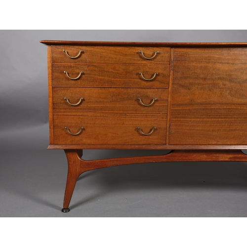 114 - Alfred Cox, A walnut sideboard 1950s having four graduated drawers with gilt metal swing handles fla... 