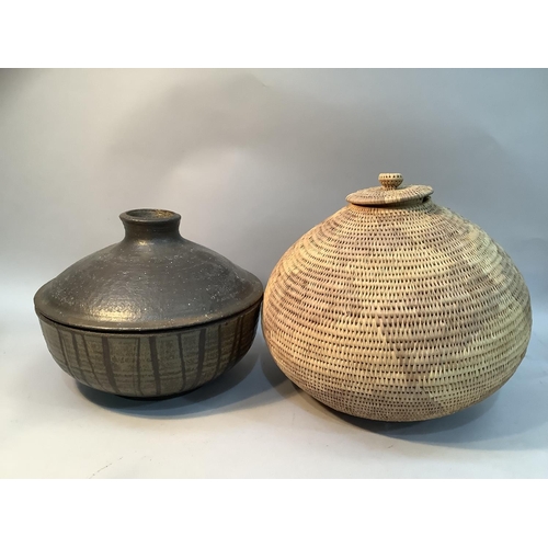 68 - A stoneware pot and cover with dripped brown glaze together with an eastern woven basket with lid