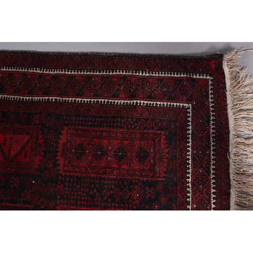 136 - An Afghan carpet, the black ground having eight deep wine rectangular panels filled with geometric d... 