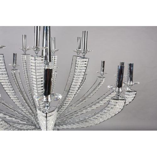 63 - A two tier white metal chandelier of eighteen lights, radiating from a central column, each arm stru... 