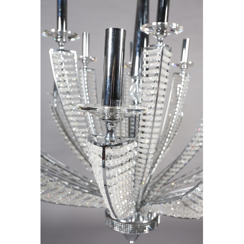 63 - A two tier white metal chandelier of eighteen lights, radiating from a central column, each arm stru... 