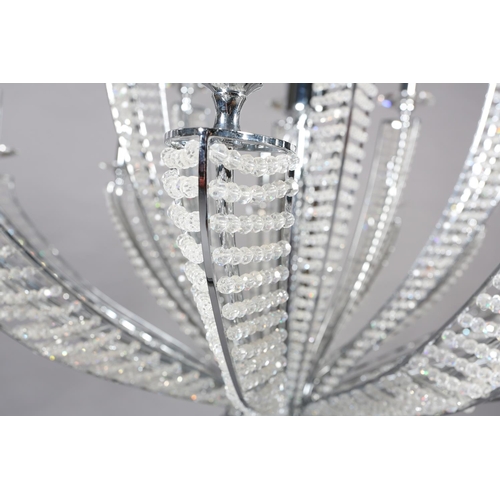 63 - A two tier white metal chandelier of eighteen lights, radiating from a central column, each arm stru... 