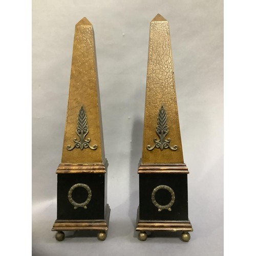 124 - A pair of ebonised and faux leather obelisks on ball feet, 48cm high