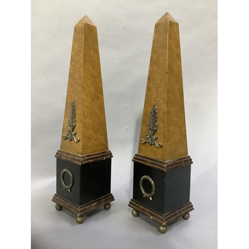 124 - A pair of ebonised and faux leather obelisks on ball feet, 48cm high