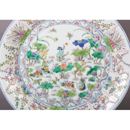 17 - A Chinese famille rose charger, painted to the centre with water fowl amongst lily pads with a wavy ... 