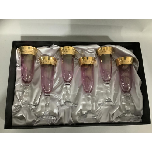 23 - A set of six amethyst Rockingham crystal flutes with gilt banding