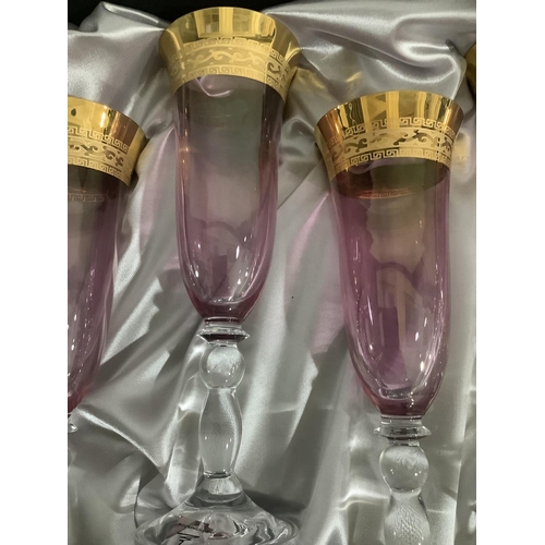 23 - A set of six amethyst Rockingham crystal flutes with gilt banding