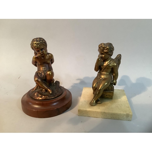 29 - A gilt metal figure of Cupid, his hands tied behind his back, his quiver of arrows beside him, raise... 