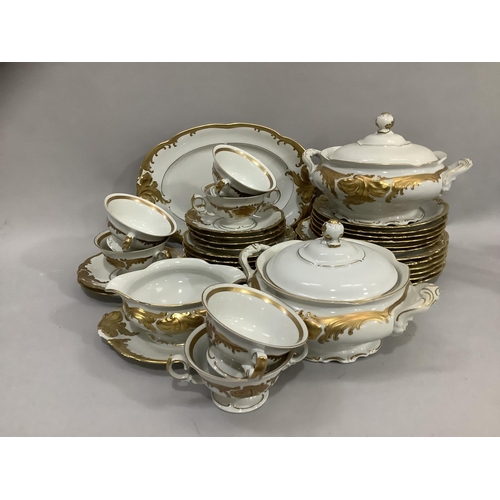 48 - A Polish china dinner service by Walbrzych, white with moulded and gilded scrolled leafage comprisin... 