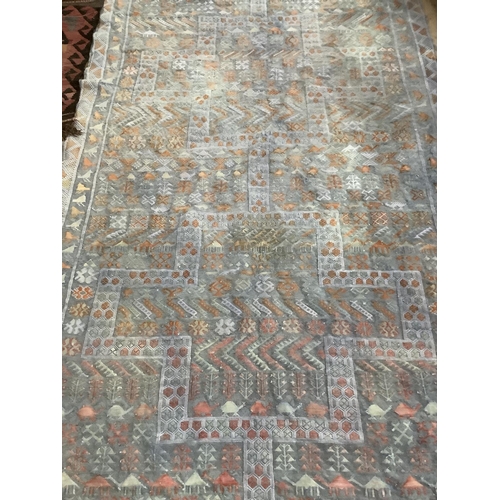 405 - A mid 20th century tapestry rug in pastel shades of blue and coral, with conjoined medallions with s... 