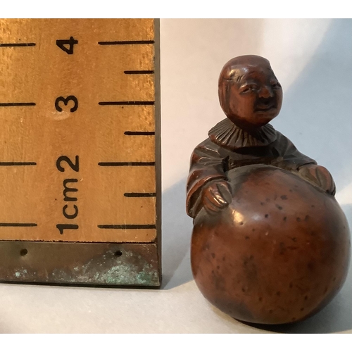 350 - A Japanese fruitwood netsuke carved as a man standing with his arms stretched around a large gourd, ... 