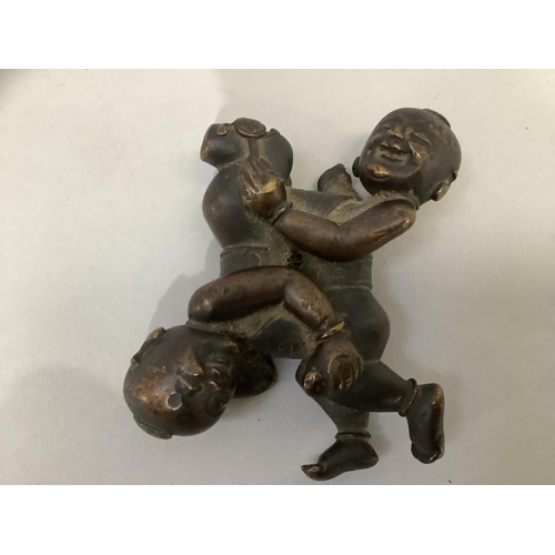 8 - A 19th Century bronze scroll weight cast as a figure group of twin boys, 7cm x 5.5cm (at fault)