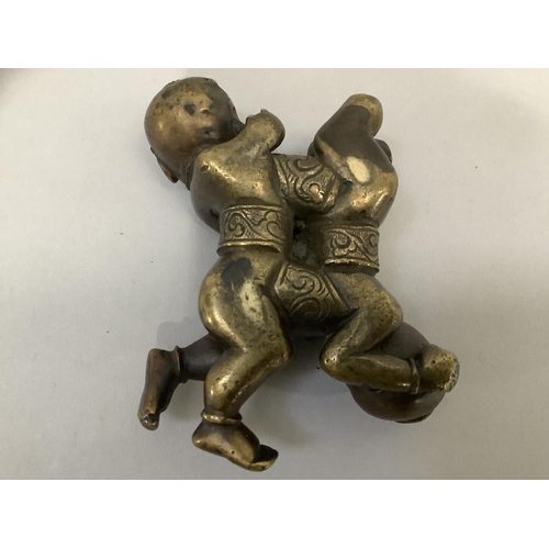 8 - A 19th Century bronze scroll weight cast as a figure group of twin boys, 7cm x 5.5cm (at fault)