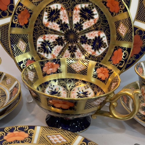 56 - A pair of Royal Crown Derby trios, cup, saucer and plate, pattern 1128, date code c1930/31, together... 