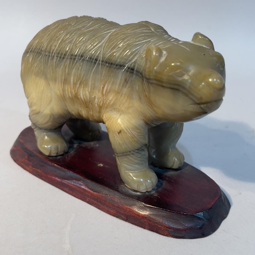 57 - A Chinese carved agate figure of a bear, on hardwood stand, 9.5cm high overall