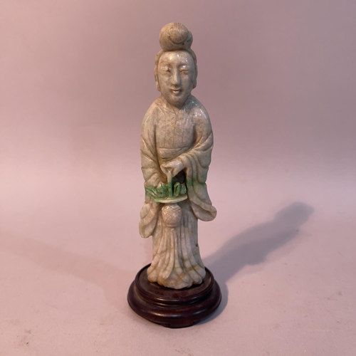 60 - A Chinese jade carving of a deity or bijin standing with a basket of fruits in her hand