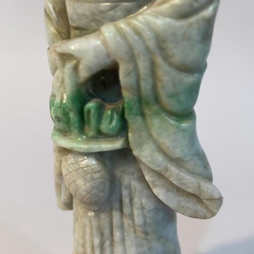 60 - A Chinese jade carving of a deity or bijin standing with a basket of fruits in her hand