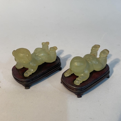 61 - A pair of Chinese green mineral twins, laying, on hardwood stands, approximate 6cm long x 4cm high o... 