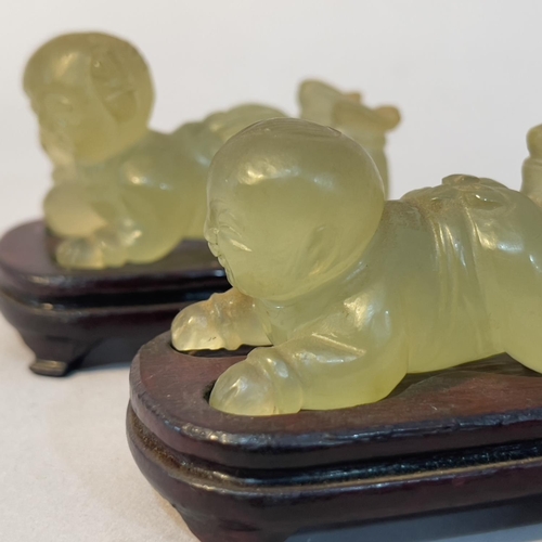 61 - A pair of Chinese green mineral twins, laying, on hardwood stands, approximate 6cm long x 4cm high o... 