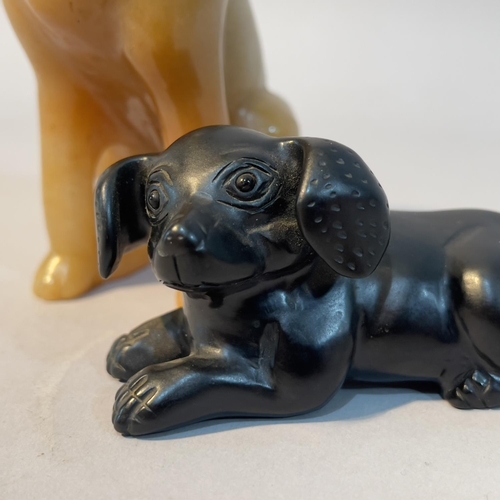 66 - A Chinese black mineral carving of a recumbent dog, 8cm long x 4cm high, together with a soapstone h... 