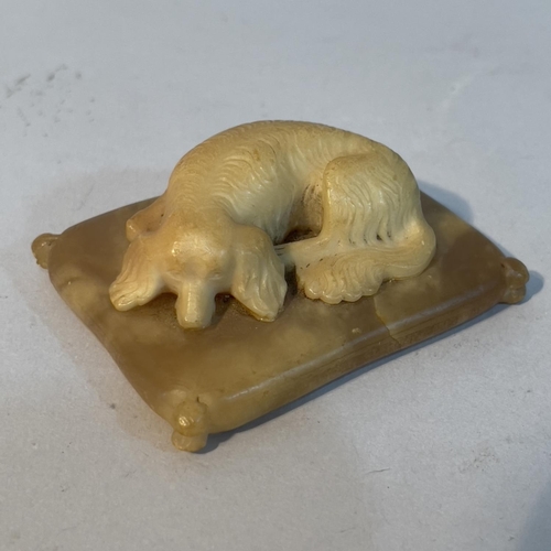 69 - A soapstone carving of a spaniel recumbent on a cushion, 6.5cm x 5cm x 2.5cm high