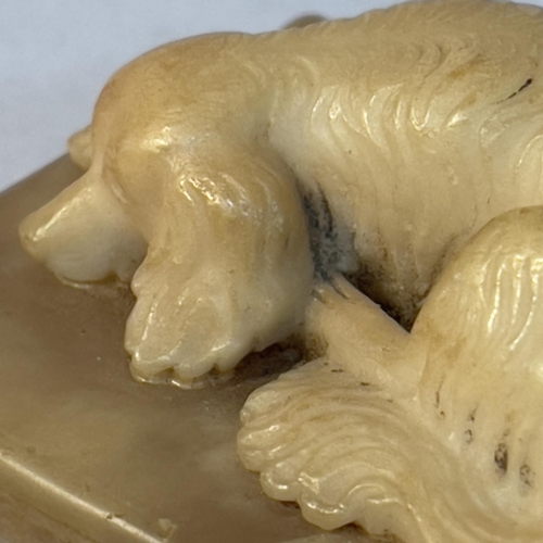 69 - A soapstone carving of a spaniel recumbent on a cushion, 6.5cm x 5cm x 2.5cm high