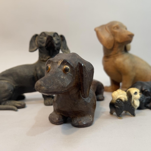 218 - Two wooden carved dachshunds, a composite spaniel and a dachshund money box