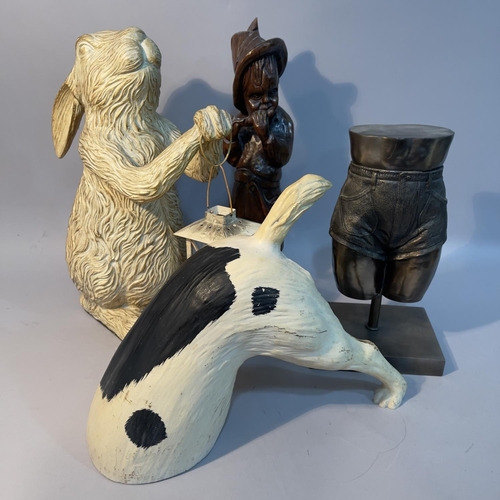 223 - A rabbit holding a lantern, model of a terrier tunnelling, wood carving of a figure playing a flute,... 