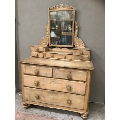 140 - A pine dressing table and drawers having two short above three long drawers below a dressing mirror ... 