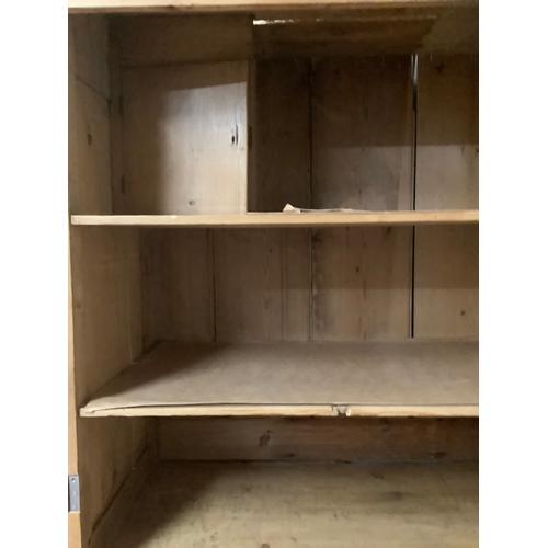 135 - A pine housekeepers cupboard a two door cupboard fitted with shelves above a base of two short and t... 