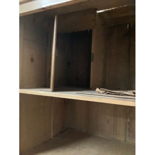 135 - A pine housekeepers cupboard a two door cupboard fitted with shelves above a base of two short and t... 