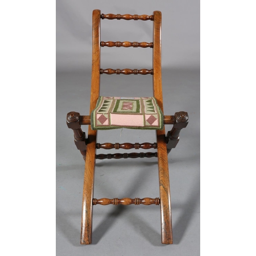 149 - A VICTORIAN CHILD'S ROSEWOOD FOLDING CHAIR WITH TRIPLE SPINDLE BAR BACK, slung needlework seat, on t... 